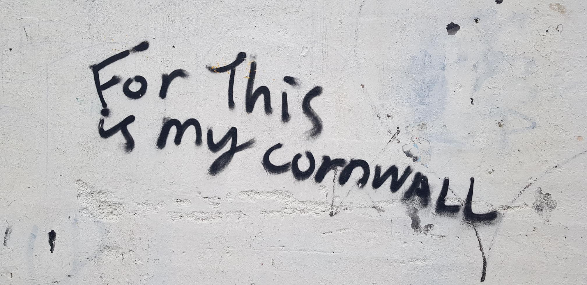 Black graffiti on a white wall. It reads "for this is my Cornwall"